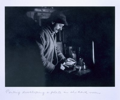 Ponting developing a plate in the dark room, from 